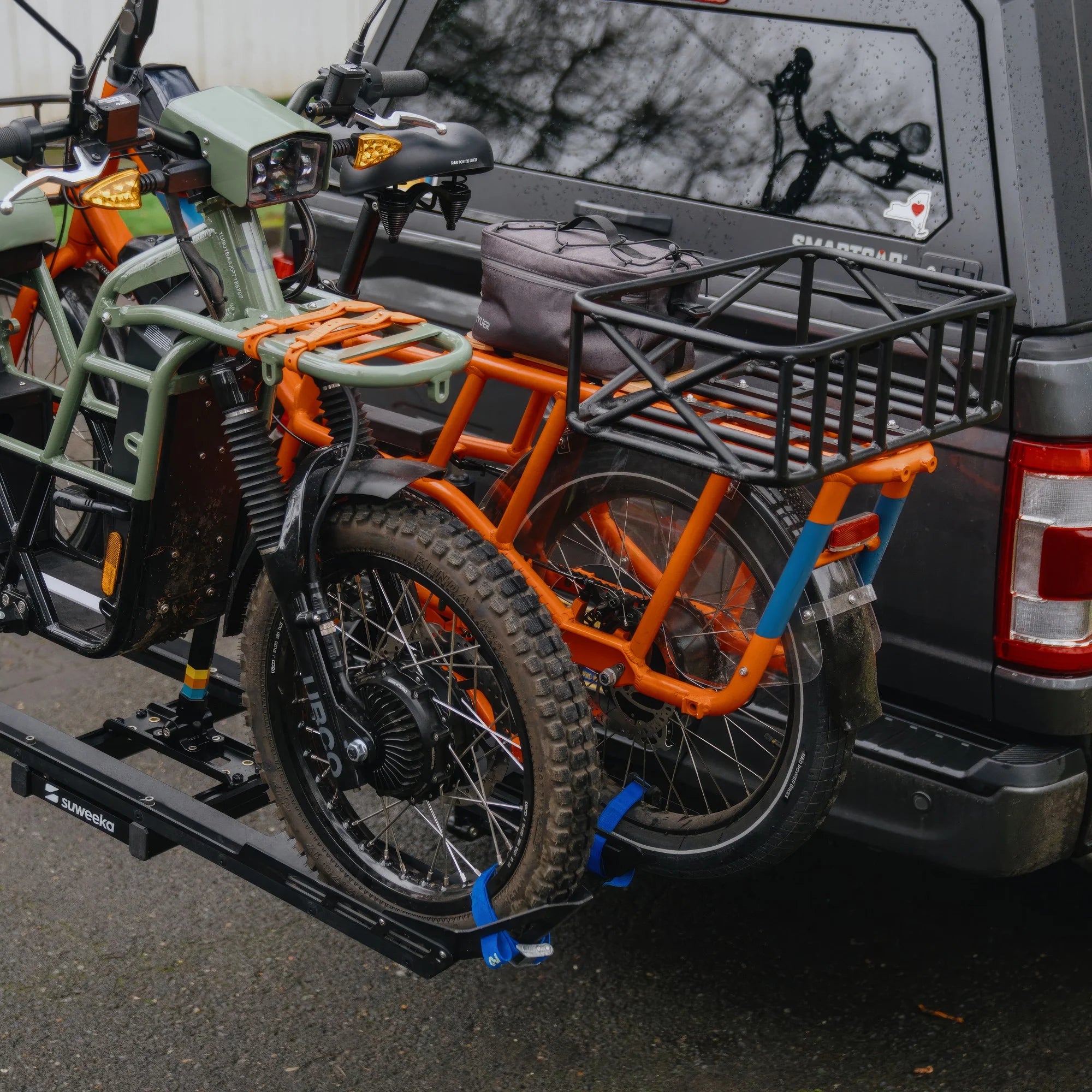 Two heavy e-bikes with baskets, and unusual frames secured in The Lifter